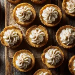 Mini pumpkin cheesecake bites with whipped cream topping and a sprinkle of cinnamon